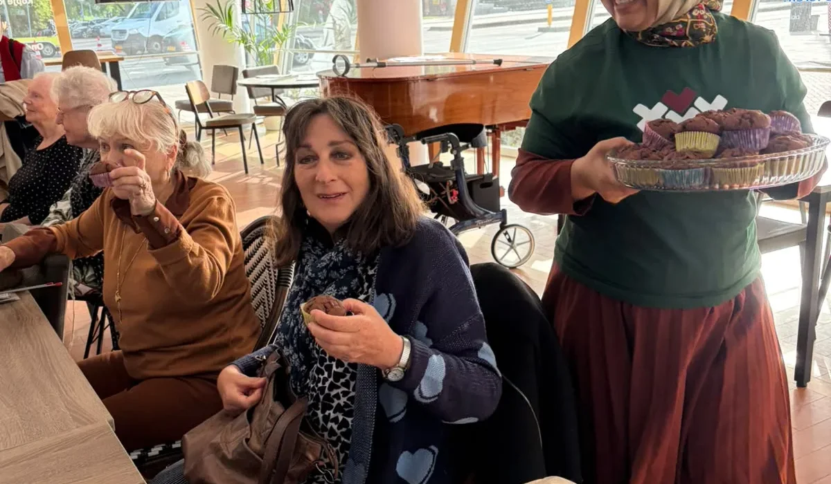 Vrijwilliger van Stichting Burgerhart deelt cupcakes uit tijdens de Week tegen Eenzaamheid