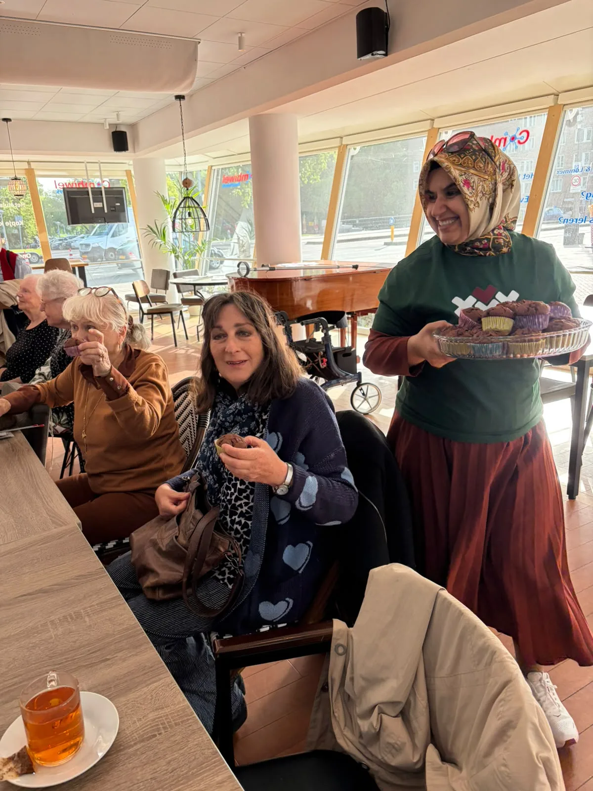 Vrijwilliger van Stichting Burgerhart deelt cupcakes uit tijdens de Week tegen Eenzaamheid
