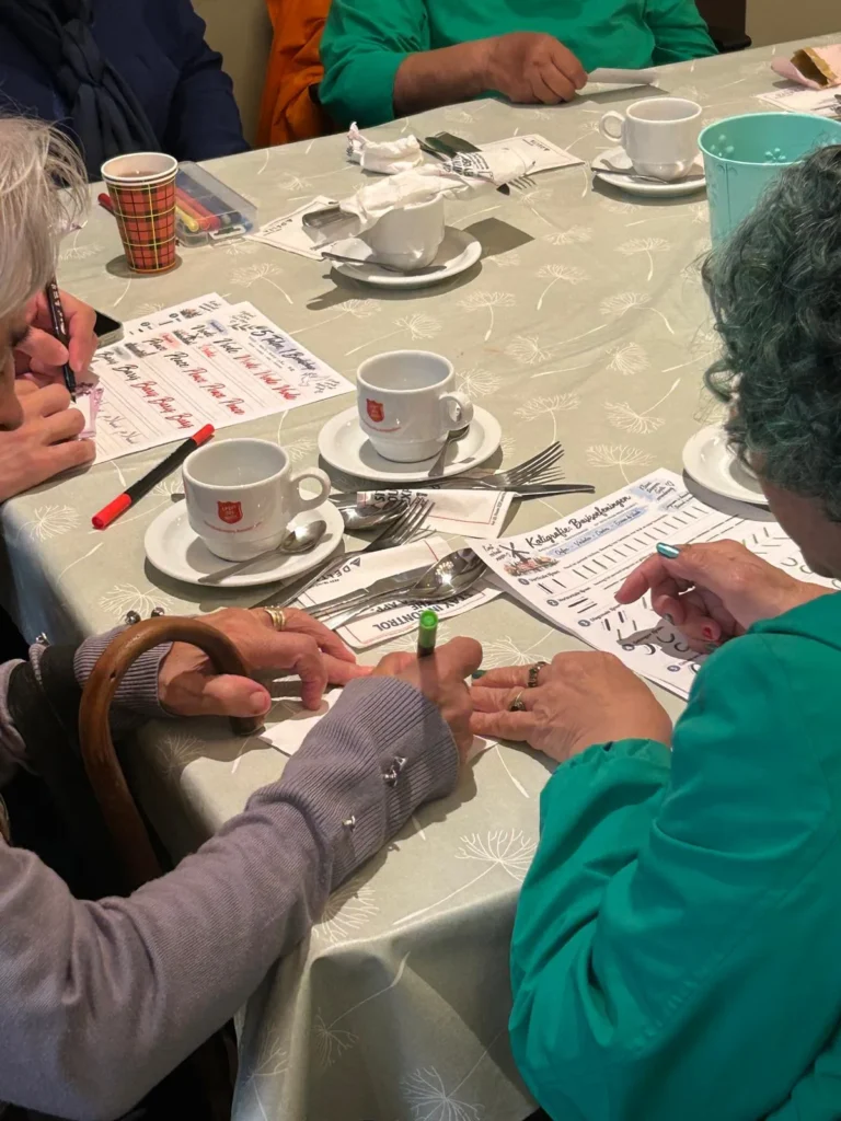 Deelneemsters aan de kalligrafieworkshop aan tafel